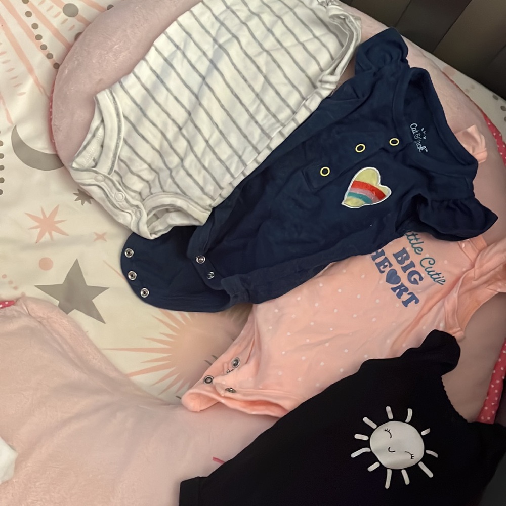 17 Newborn onsies, a pair of shorts, and a sleep sack. All in great condition.